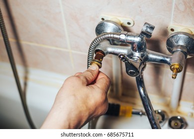 Man Repair And Fixing Leaky Faucet In Bathroom