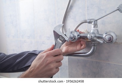 Man Repair And Fixing Shower Faucet In Bathroom.