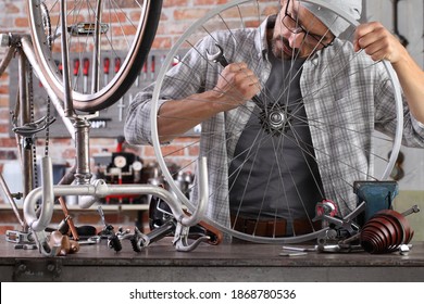 Man Repair The Vintage Bicycle In Garage Workshop On The Workbench With Tools, Diy Concept