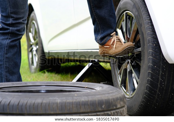 Man repaired\
wheeled vehicles on the road, Replacing winter and summer tires.\
Seasonal tire replacement\
concept