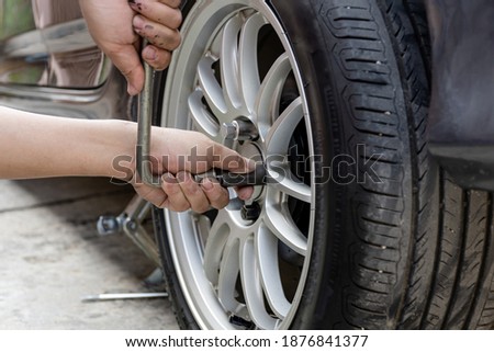 A man repairing action lock bolt of car wheel for check the car's drive system basic maintenance that can be made by yourself