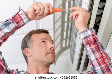 Man Repairing An Air Conditioning Unit