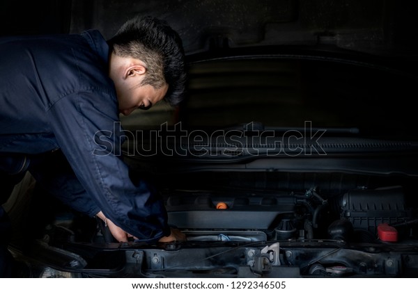 Man repairing a car, Using a wrench and a
screwdriver to work.Safe and confident in driving. Regular
inspection of used cars. It is very well
done.