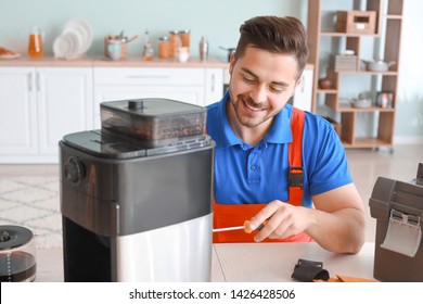 Man Repairing Coffee Machine In Kitchen