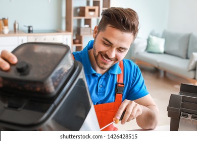 Man Repairing Coffee Machine In Kitchen