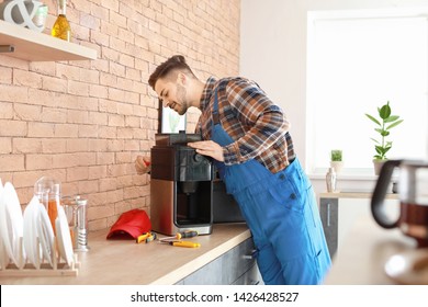 Man Repairing Coffee Machine In Kitchen