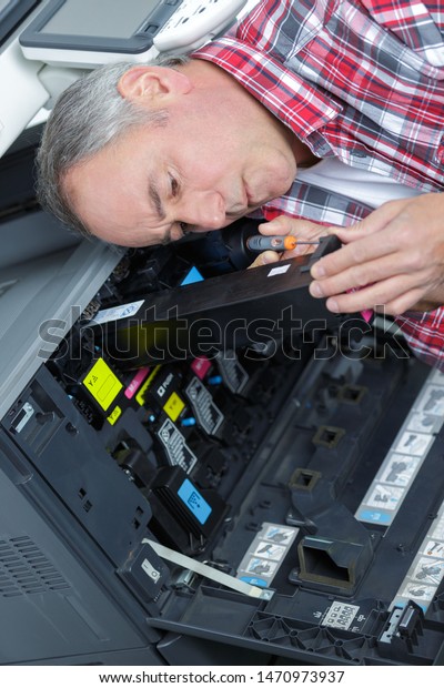 man\
repairing color printer changing toner\
cartridge