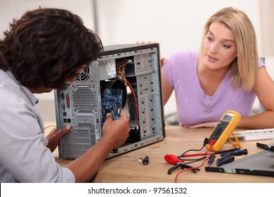 man repairing computer under his wife's