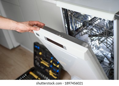 Man Repairing A Dishwasher With Tools