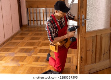 Man repairing door lock. Hand of the repairman with a screwdriver