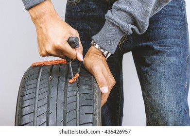The Man Repairing Flat Car Tire With Repair Kit, Tire Plug Repair Kit For Tubeless Tires.