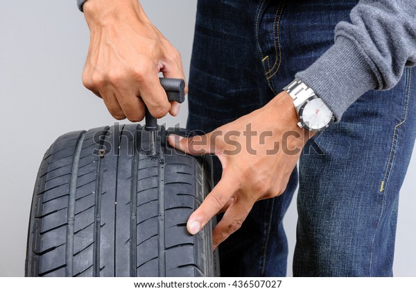 The man repairing flat car tire with
repair kit, Tire plug repair kit for tubeless
tires.