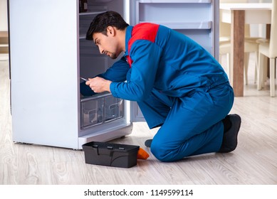 Man Repairing Fridge With Customer