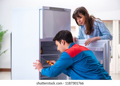 Man Repairing Fridge With Customer