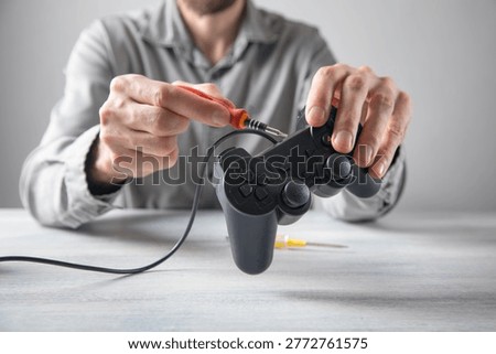Man repairing a game controller.