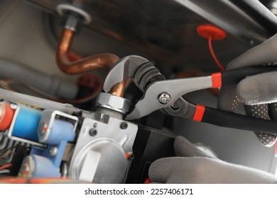 Man repairing gas boiler with waterpump plier, closeup - Shutterstock ID 2257406171