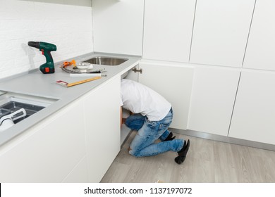 Man Repairing A Kitchen Sink At Home