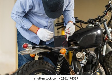 Man repairing motorcycle in repair shop, Mechanic fixing motorbike in workshop garage, Repairing and maintenance concepts - Powered by Shutterstock