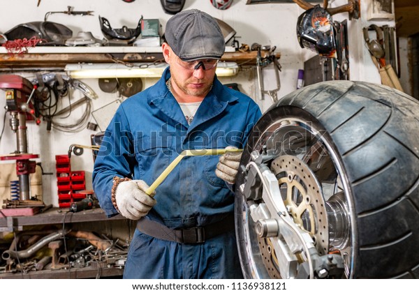 The man repairing motorcycle tire\
with repair kit, Tire plug repair kit for tubeless\
tires.