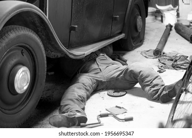 Man repairing old vintage front-wheel drive car - Powered by Shutterstock