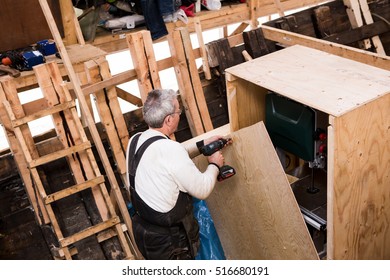 Man  repairing old wooden fishing boat. - Powered by Shutterstock