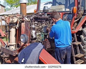 Man Repairing Vintage Tractor Engine At Home