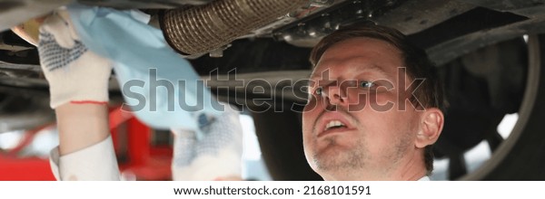 Man\
repairman repairing car under hood at service\
station