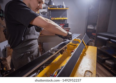 A Man Repairman In Workshop Ski Service Repairing The Ski