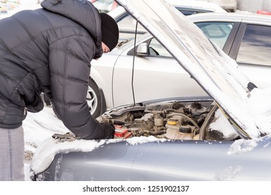 A Man Repairs A Broken Car In The Winter, Broke Down In The Cold, The Car Will Not Start