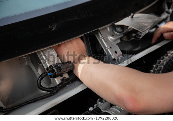 a man repairs a car. a man in blue\
special clothes to repair the car. engine parts machine repair\
maintenance breakage problem hands people man\
master