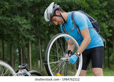 man repairs the rear wheel of his bicycle - Powered by Shutterstock