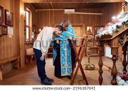 a man repents of his sins, confesses with a priest in the Orthodox church.