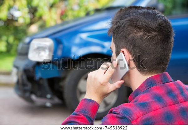 Man Reporting Car\
Crash On Mobile Phone
