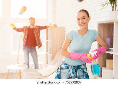 A man reproaches a girl during cleaning in a bright apartment. She rests while he works alone. He is nervous because of this. They work in rubber gloves, use sponges, water sprayers, dust brushes. - Powered by Shutterstock