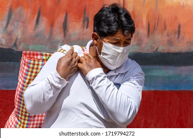 Man In Respiratory Mask During Coronavirus Pandemic In Market With Bag Of Food In Cusco, Peru In Latin South America. Epidemic Of Coronavirus Covid-19