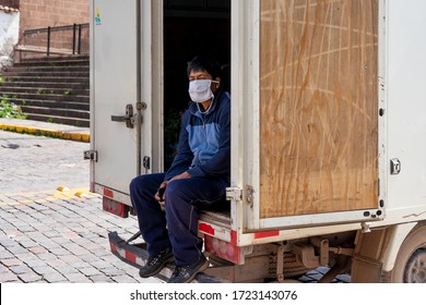 Man in respiratory mask sits inside track during coronavirus pandemic in market in Cusco, Peru in Latin South America. Epidemic of coronavirus covid-19