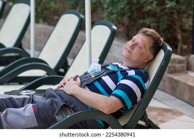 Man resting after hard work lying sunbed under umbrella. - Shutterstock ID 2254380941