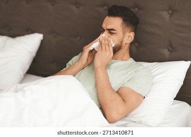 Man Resting in Bed While Feeling Unwell and Dealing With Cold Symptoms