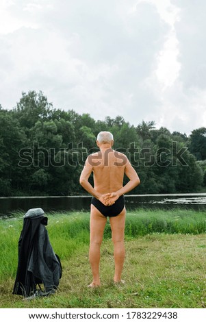 Similar – sports guy in his underwear looking at the river