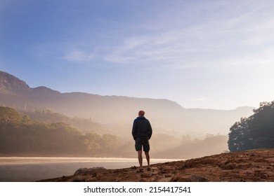 A man is resting at ease by the calm lake. Relaxation vacation - Shutterstock ID 2154417541