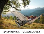 Man resting in hammock outdoors at sunset