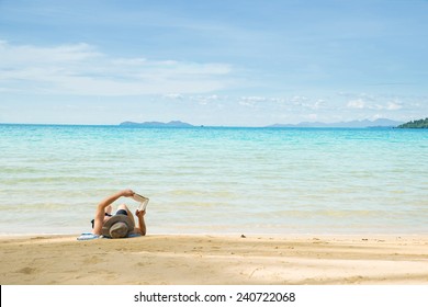 Man Resting On Beach And Reading Book