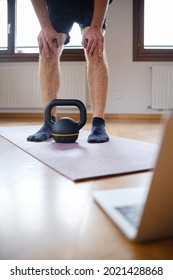 Man Resting On His Knees During An Online Exercise Class At Home. Vertical Photo.