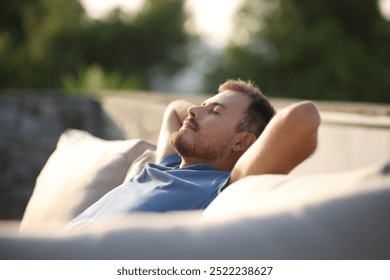 Man resting and relaxing alone sitting in couch in a terrace at home - Powered by Shutterstock