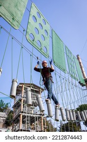 A Man Is Resting In A Rope Amusement Park. Vertical Photo.