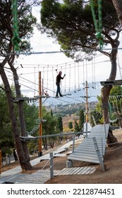 A Man Is Resting In A Rope Amusement Park. Vertical Photo.