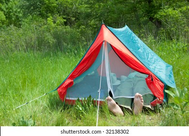 Man resting in a tent on a green glade