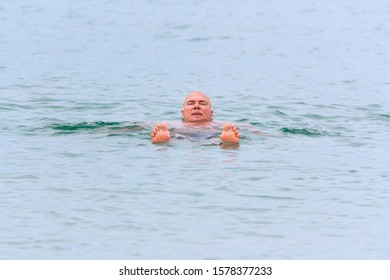 A man rests lying on the surface of sea salt water