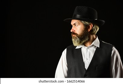 Man with retro Hat. brutal bearded hipster in suit vest. mafia gentlemen club. mature cowboy. detective acknowledgement or greeting. trilby hat. man in vintage style wide brimmed hat. copy space.