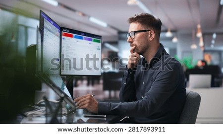 Man Reviews Software Dashboard Using Touchscreen To Track Compliance Risks.